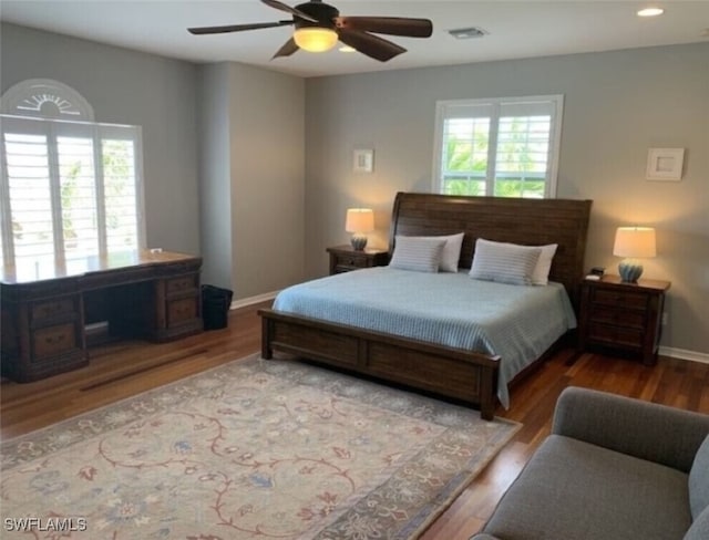 bedroom with multiple windows, ceiling fan, and hardwood / wood-style flooring