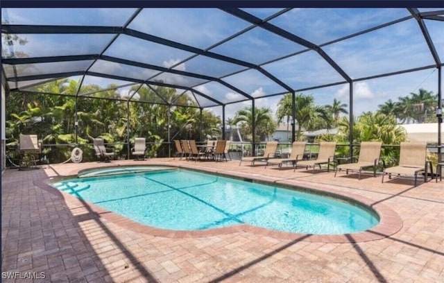 view of swimming pool with glass enclosure and a patio area