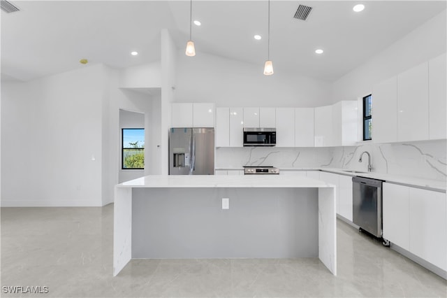 kitchen with appliances with stainless steel finishes, sink, pendant lighting, a center island, and white cabinetry