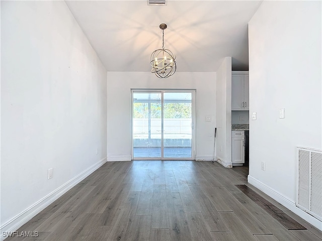 unfurnished dining area with dark hardwood / wood-style flooring and a notable chandelier