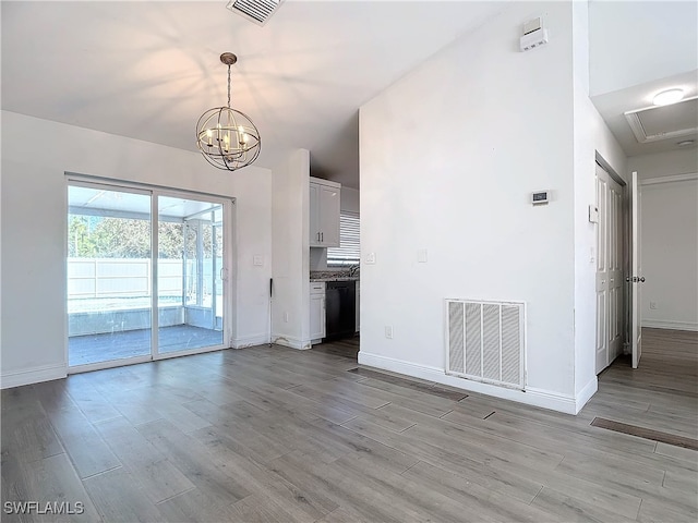 unfurnished living room featuring light hardwood / wood-style flooring and an inviting chandelier