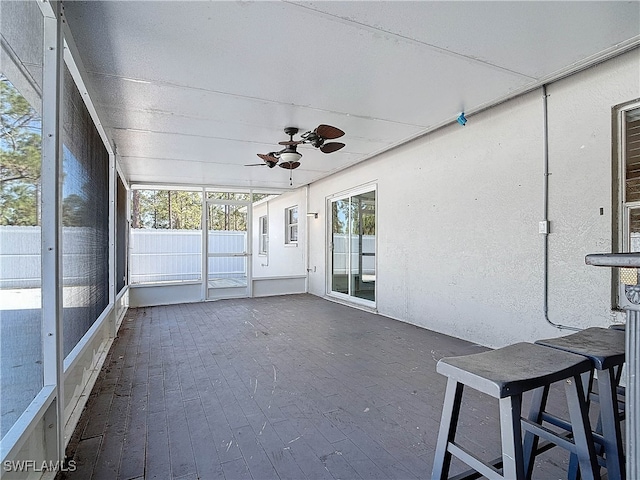 unfurnished sunroom with ceiling fan