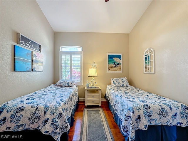 bedroom featuring ceiling fan, lofted ceiling, and dark wood-type flooring