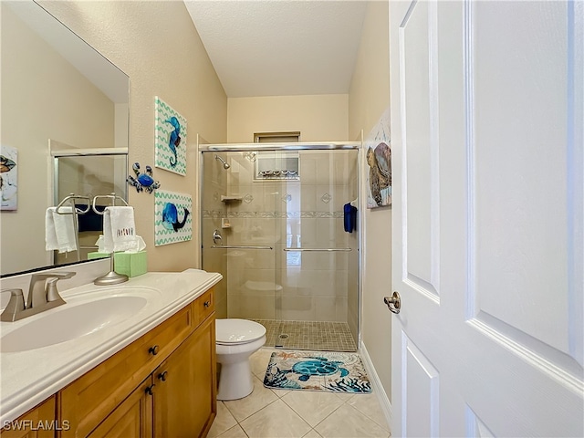 bathroom with vanity, tile patterned flooring, toilet, walk in shower, and a textured ceiling