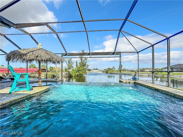 view of swimming pool with a patio, a water view, and glass enclosure