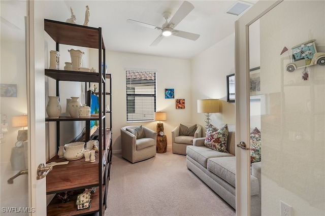 sitting room featuring ceiling fan and carpet