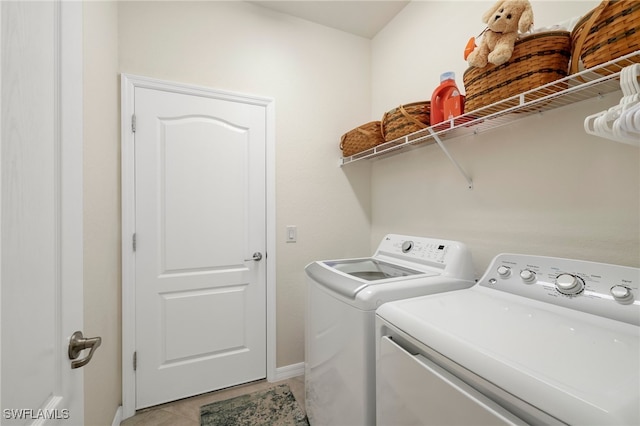 clothes washing area with washer and clothes dryer and light tile patterned floors