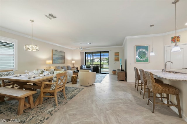 dining room featuring sink, ceiling fan, and ornamental molding