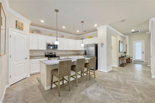 kitchen featuring stainless steel appliances, an island with sink, white cabinetry, and light stone countertops