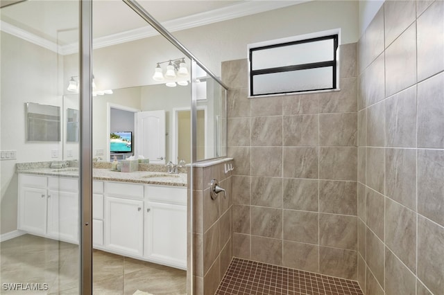 bathroom with ornamental molding, tiled shower, and vanity