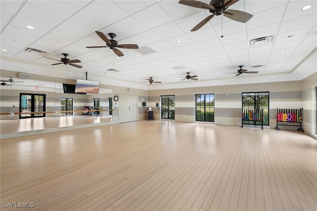 interior space featuring a paneled ceiling and light hardwood / wood-style flooring