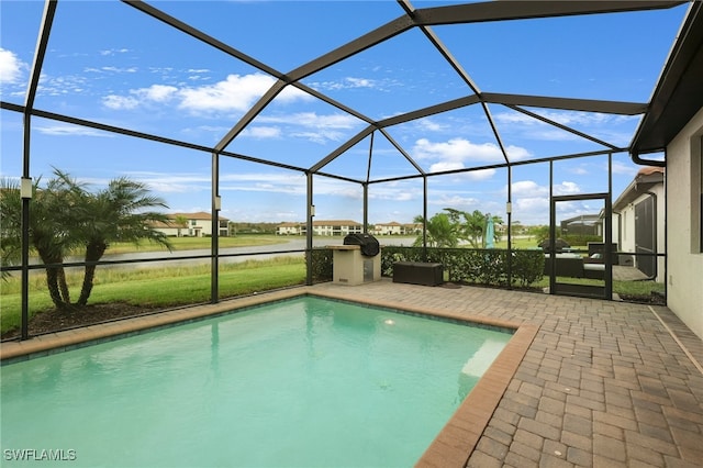 view of swimming pool featuring glass enclosure and a patio