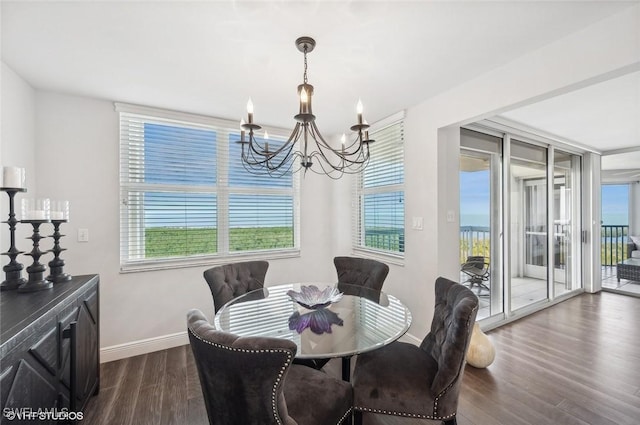 dining area with dark wood-type flooring and a notable chandelier