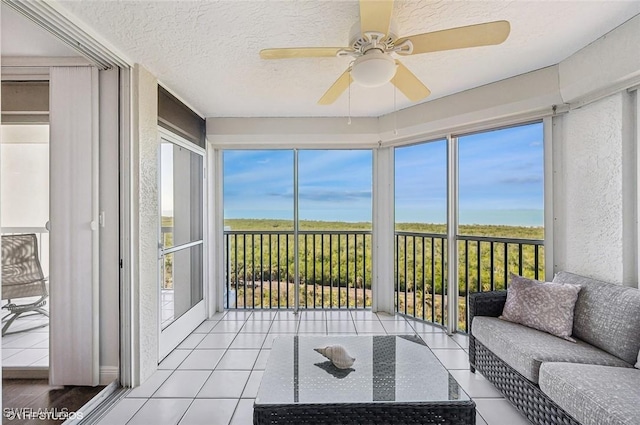 sunroom / solarium featuring ceiling fan, plenty of natural light, and a water view