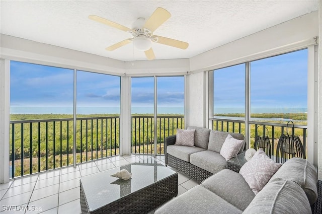 sunroom featuring a water view and ceiling fan