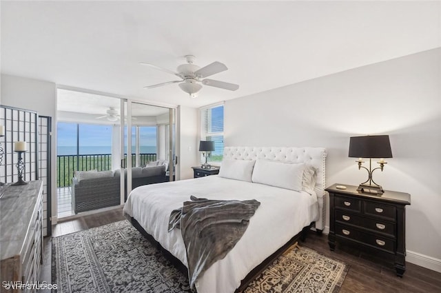 bedroom featuring access to outside, ceiling fan, dark wood-type flooring, and a water view