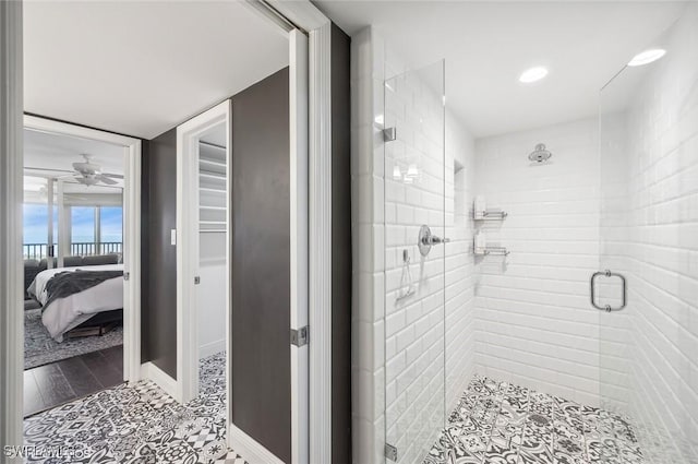 bathroom featuring a shower with door and ceiling fan