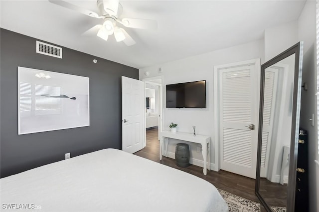 bedroom with ceiling fan, dark wood-type flooring, and a closet