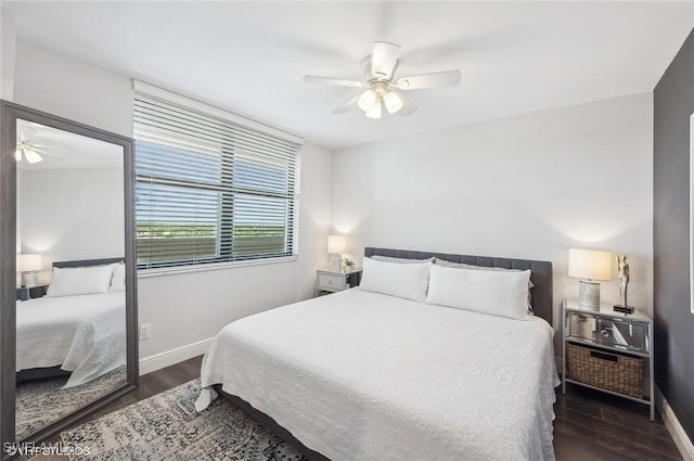 bedroom with dark hardwood / wood-style flooring and ceiling fan