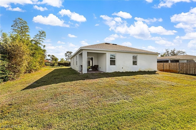 rear view of house featuring a lawn and a patio