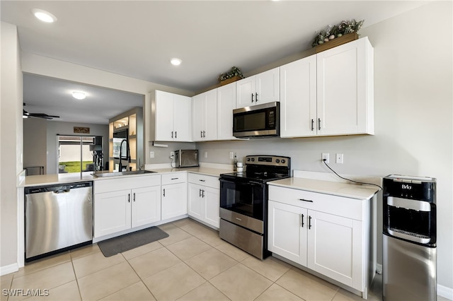 kitchen with white cabinets, sink, ceiling fan, appliances with stainless steel finishes, and light tile patterned flooring