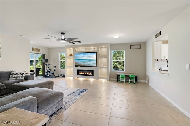 living room with ceiling fan, sink, a wealth of natural light, and light tile patterned flooring