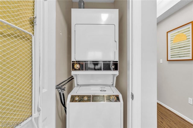 900 Arbor Lake Dr Unit 9-101, Naples, FL 34110 - laundry room with stacked washer / drying machine, wood finished floors, and baseboards