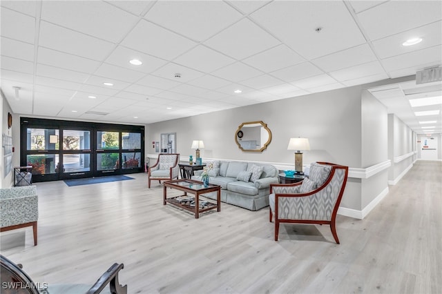 living room with wood finished floors, a paneled ceiling, and recessed lighting