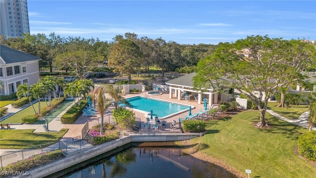 view of pool with a patio area, a lawn, and a water view