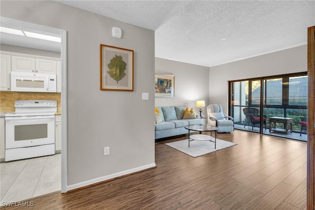 900 Arbor Lake Dr Unit 9-101, Naples, FL 34110 - living area featuring a textured ceiling, baseboards, and light wood-style flooring