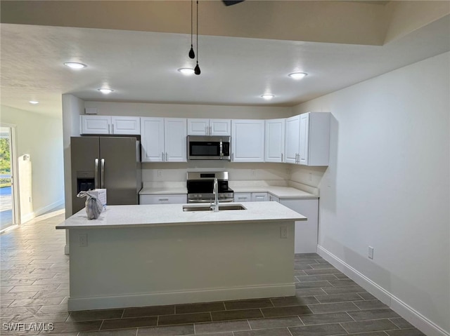 kitchen with stainless steel appliances, white cabinetry, dark hardwood / wood-style floors, and an island with sink