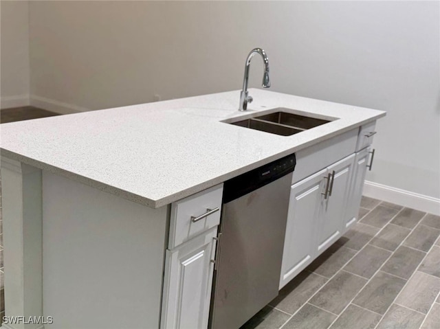 kitchen with white cabinetry, a kitchen island with sink, sink, and stainless steel dishwasher