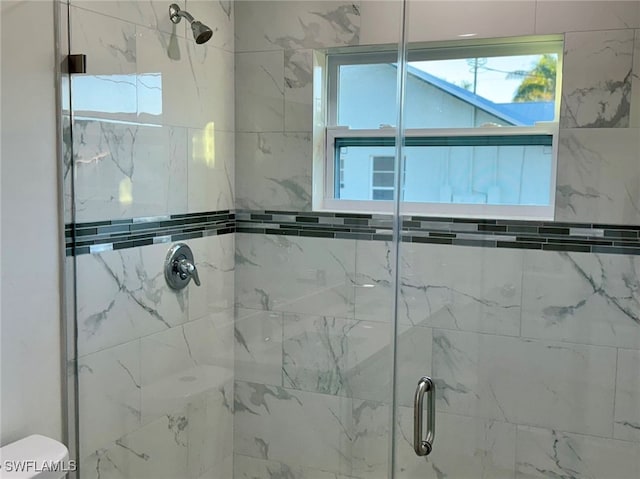 bathroom featuring toilet and an enclosed shower