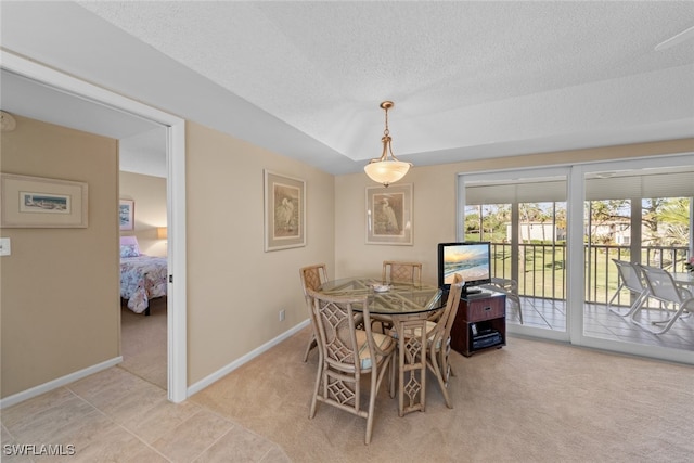 carpeted dining room with a textured ceiling