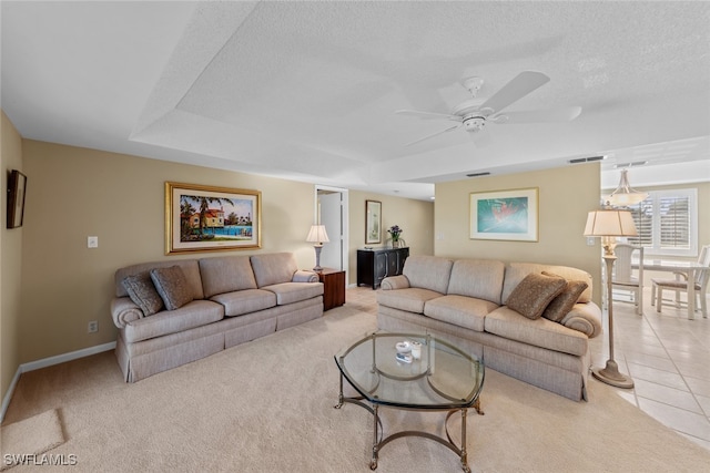 carpeted living room featuring ceiling fan and a textured ceiling