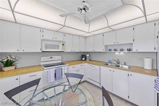 kitchen with white appliances, white cabinetry, ceiling fan, and sink