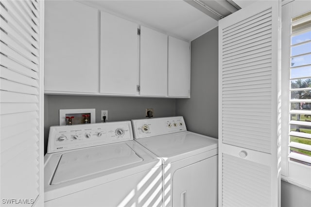 clothes washing area featuring a healthy amount of sunlight, cabinets, and washing machine and dryer