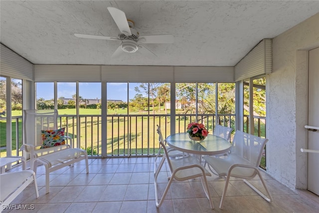 unfurnished sunroom featuring ceiling fan and a healthy amount of sunlight