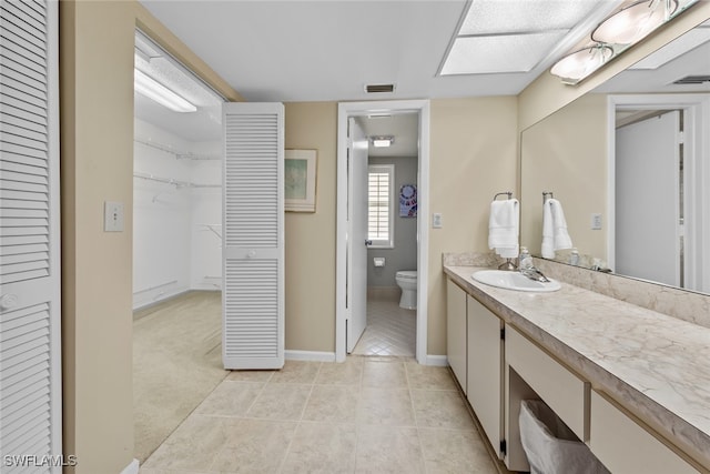 bathroom with tile patterned flooring, vanity, and toilet