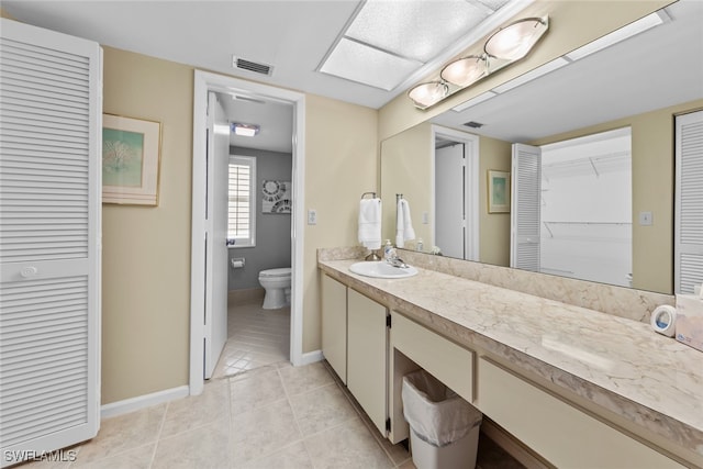 bathroom featuring tile patterned flooring, vanity, and toilet