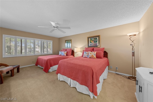 carpeted bedroom with ceiling fan and a textured ceiling