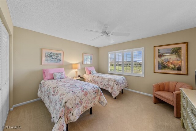 bedroom with ceiling fan, a closet, and light carpet