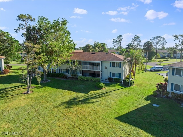 back of house with a yard and a balcony