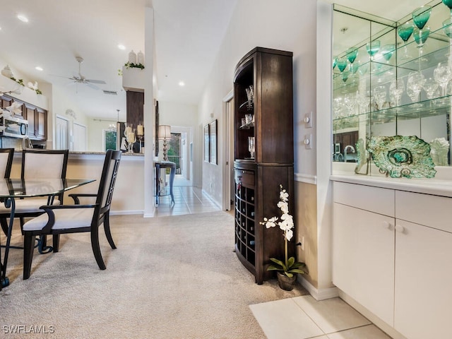 dining space featuring ceiling fan and light colored carpet