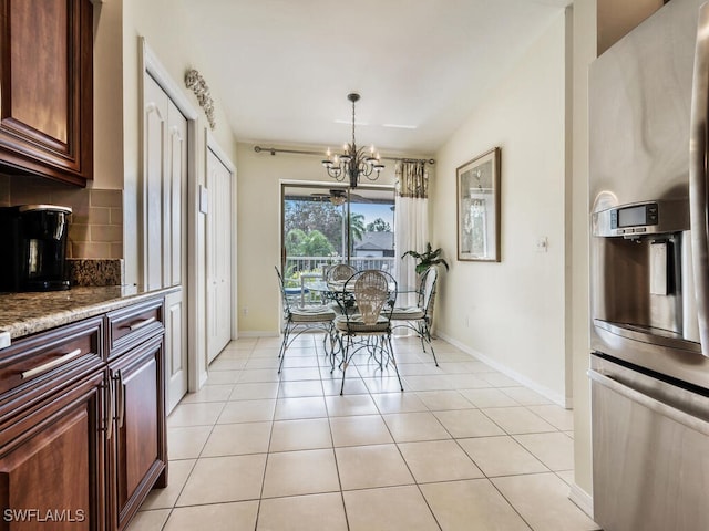 tiled dining space featuring vaulted ceiling and a chandelier