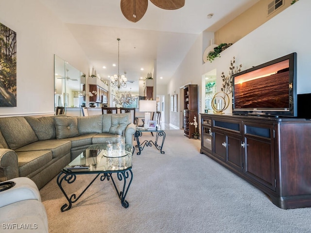 living room featuring ceiling fan with notable chandelier, high vaulted ceiling, and light carpet