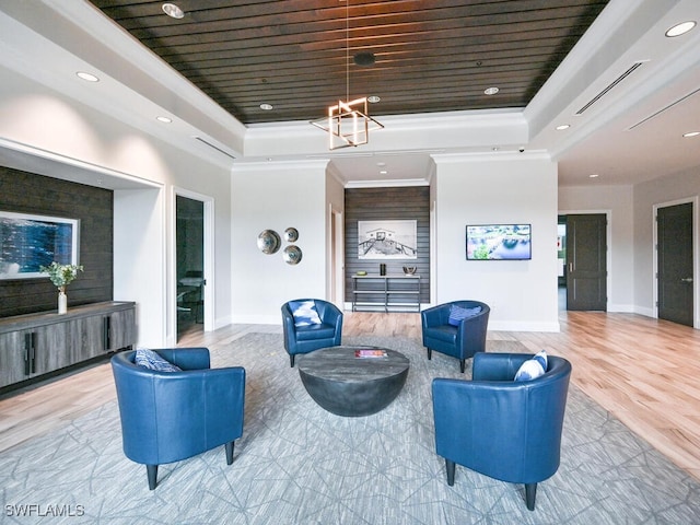 interior space with wood ceiling, a tray ceiling, a notable chandelier, light wood-type flooring, and crown molding