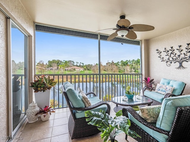 sunroom / solarium with ceiling fan and a water view