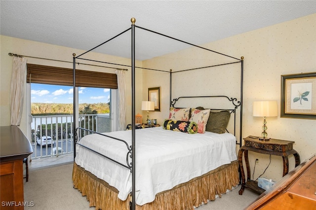 carpeted bedroom featuring a textured ceiling and access to outside