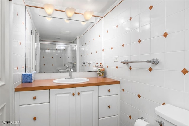 bathroom featuring an enclosed shower, vanity, toilet, and tile walls